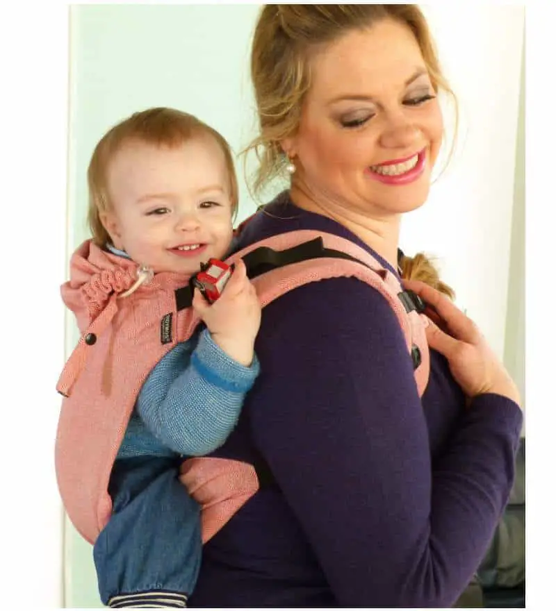 Baby in the best travel baby carrier behind mother