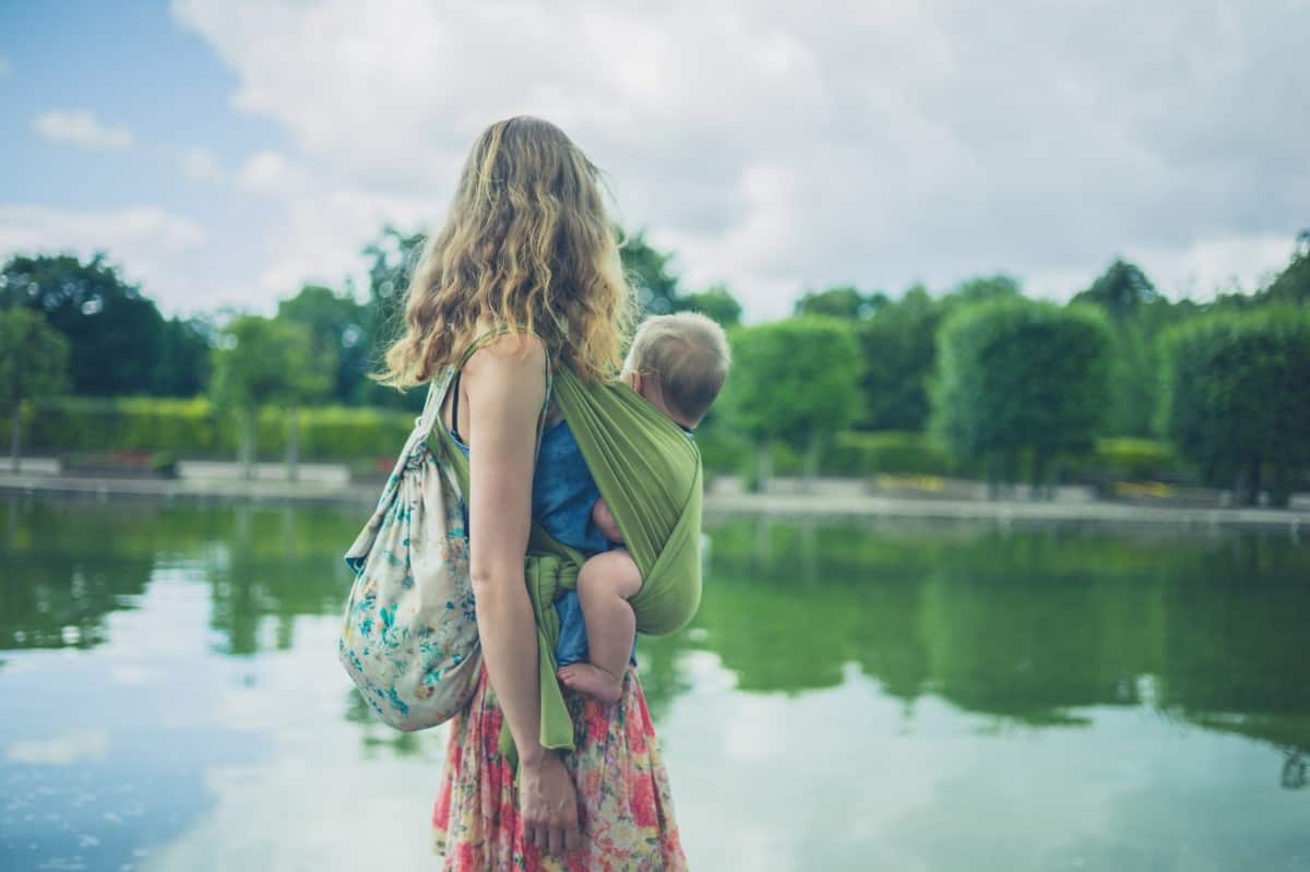 mother looking at the water with her child in her best water baby carrier