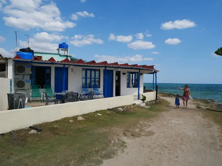 A woman and a little girl walking outside a beachfront bed and breakfast in Playa Larga, Cuba.