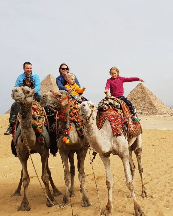 family camel riding near the pyramids