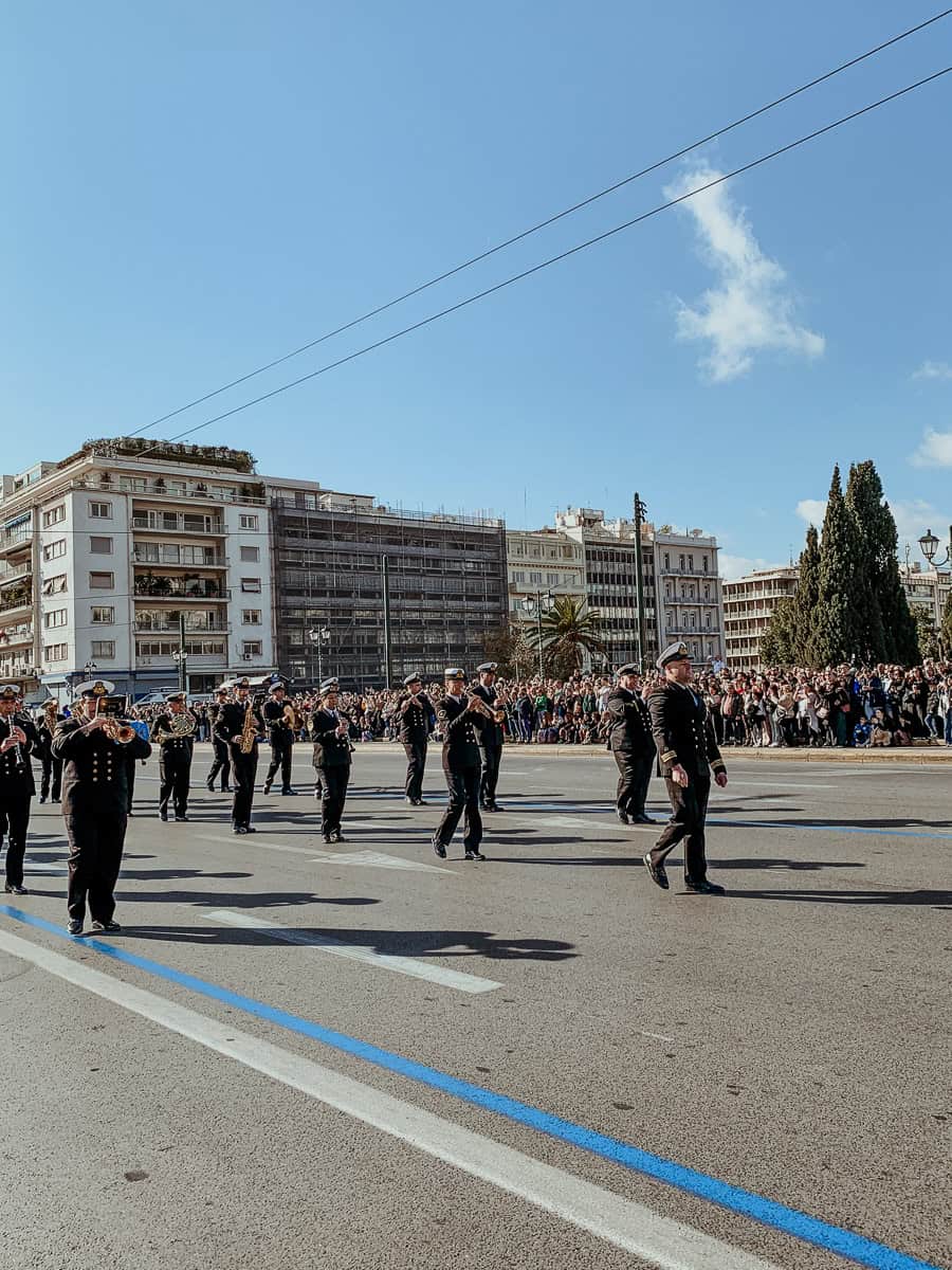 The brass band marching by, wearing a black costume.