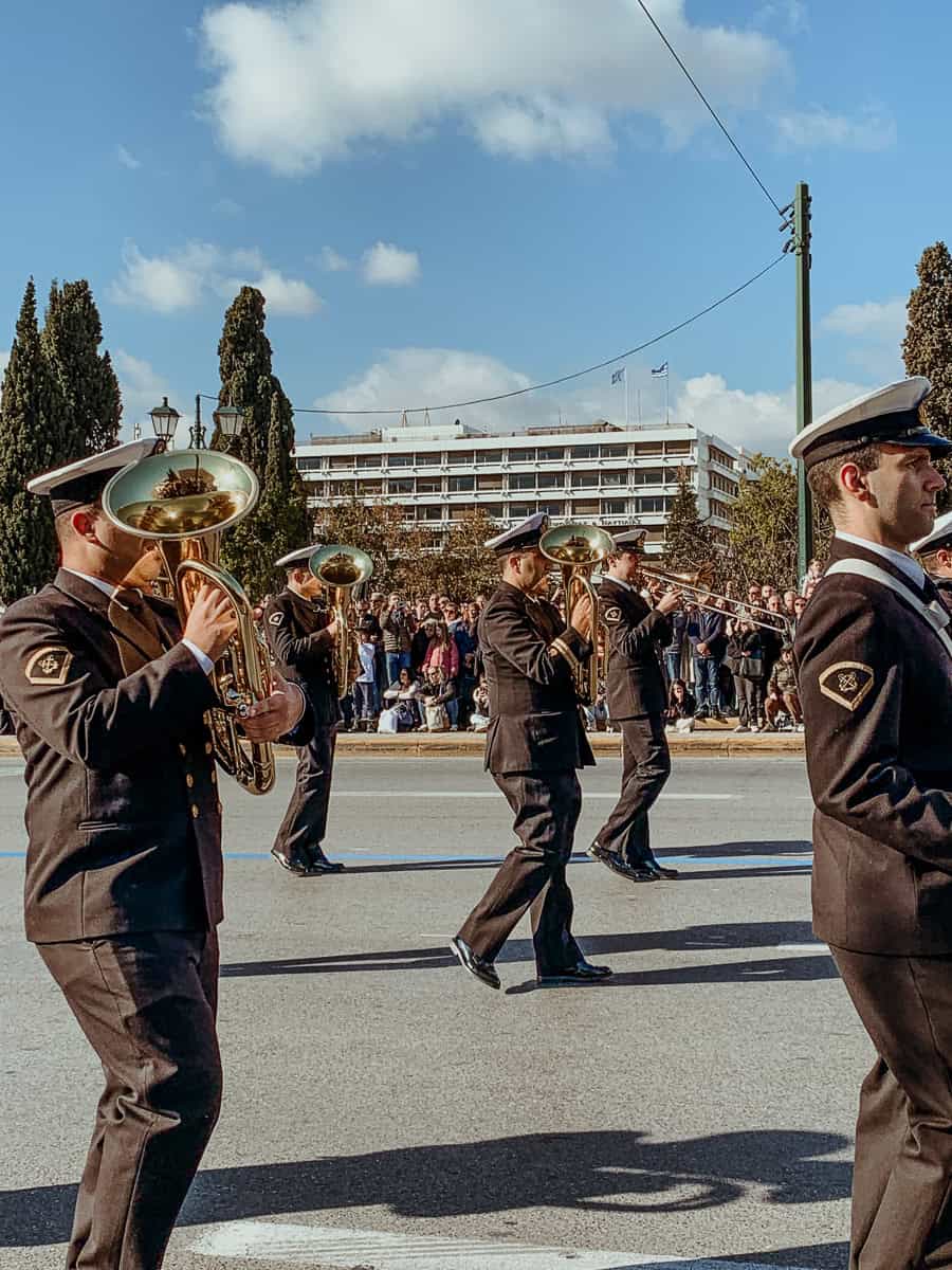 The brass band marching by, wearing a black costume.
