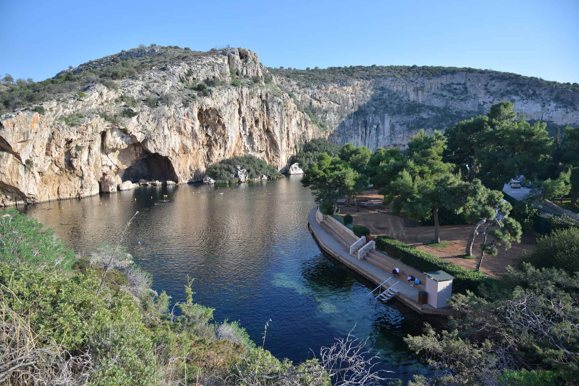 The Lake Vouliagmeni under clear blue skies.