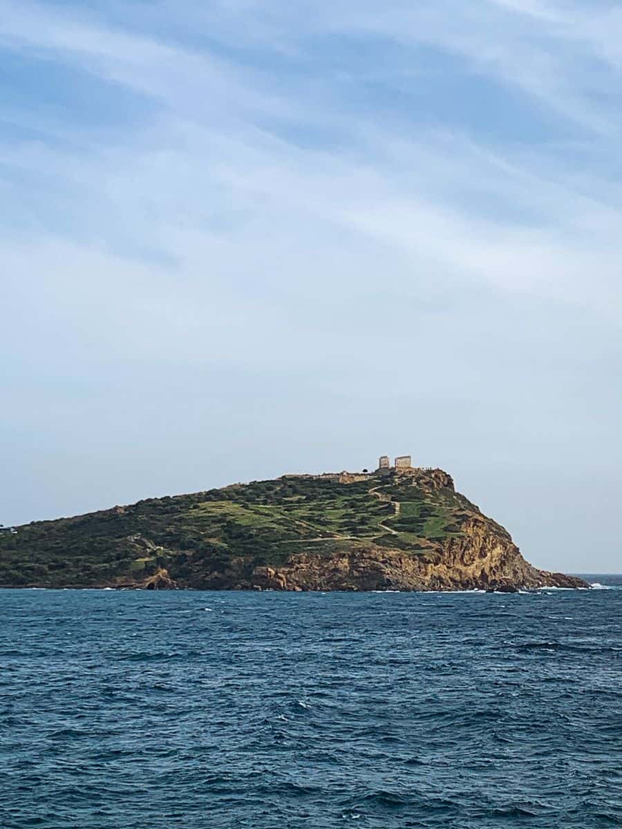 An island from afar under the blue skies.