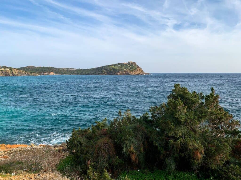 An island from afar under the blue skies and view of the cliff.