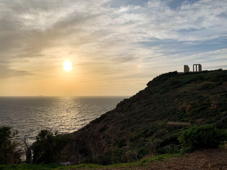Temple of Poseidon on a sunset, with the island's silhouette.
