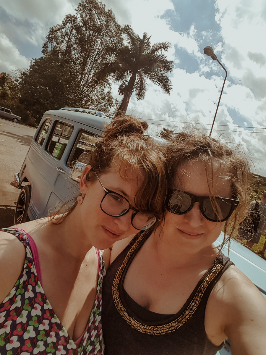 Kath and Babs with a Willys Jeep Wagon behind them on a sunny day.