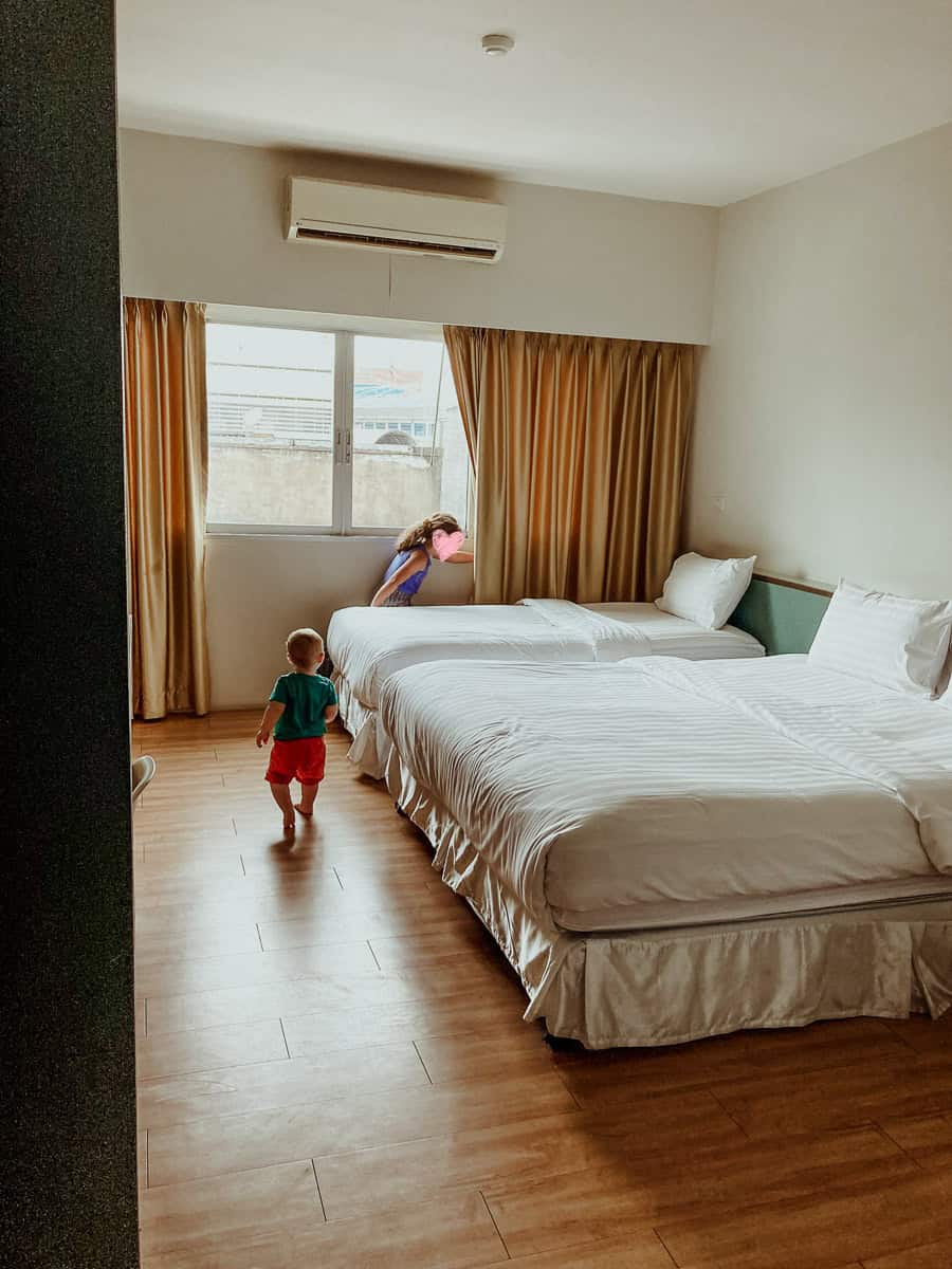 Oscar walks toward the window while Norah peers through the curtains.