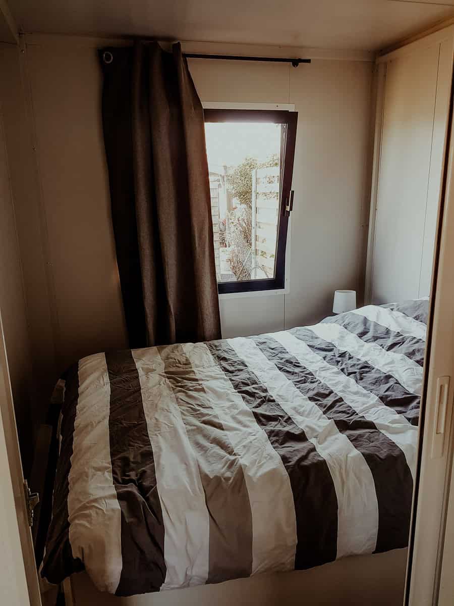 Cozy hotel room with a bed and window, perfect for family stays with a baby.