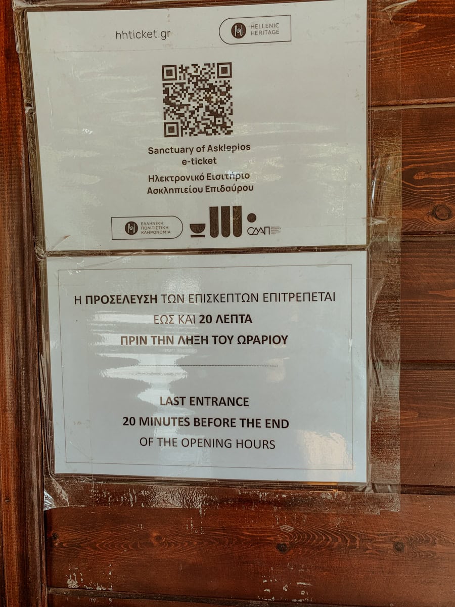 Two printed signs showing an e-ticket QR code for the Sanctuary of Asklepios and a last entrance warning notice.