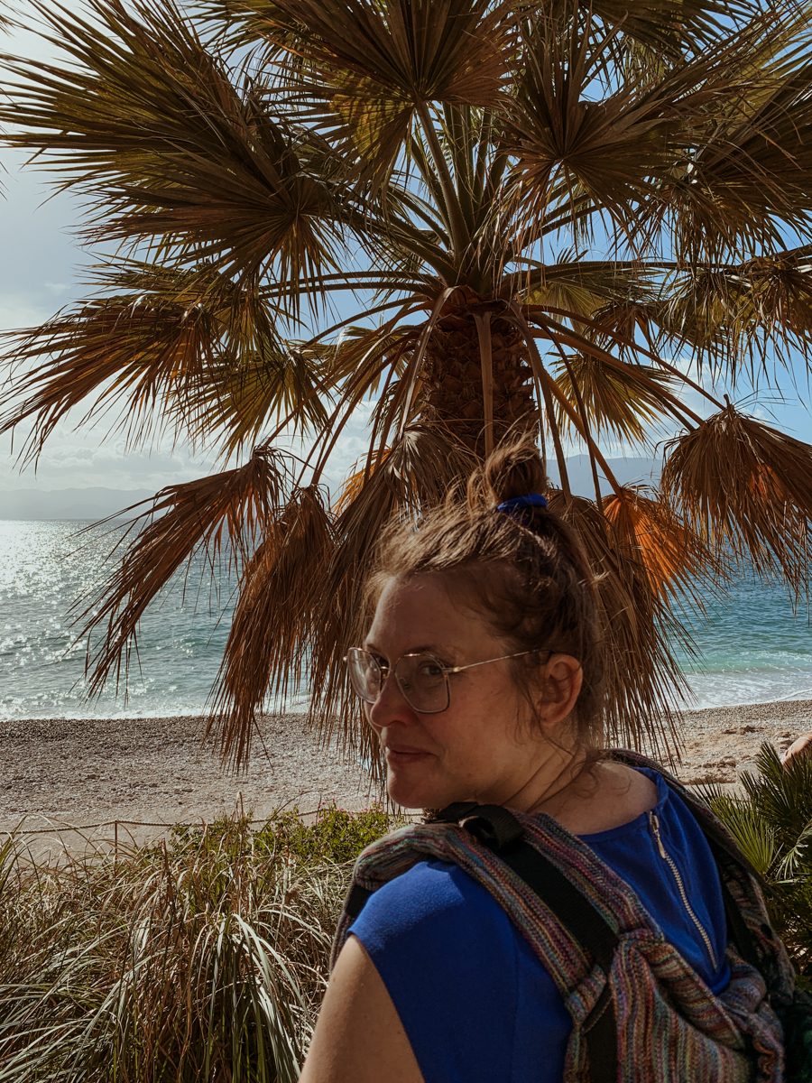 Babs in front of a palm tree at Paralia Arvanitias.