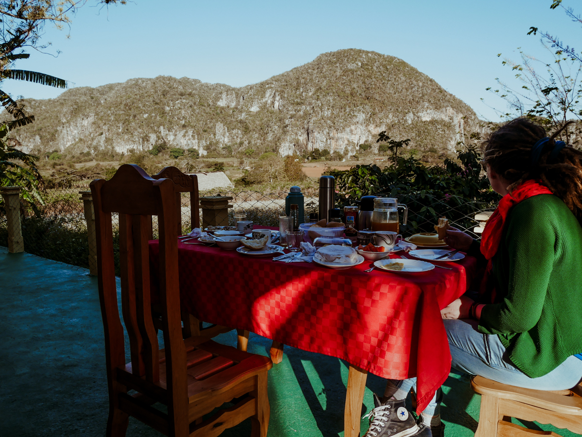 Kath enjoys breakfast at Casa Milagros y Yamilé while looking out at a large limestone mogote surrounded by a lush valley.